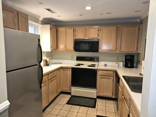 a kitchen with wooden cabinets and black and white appliances at Teal Lake 1413 in North Myrtle Beach