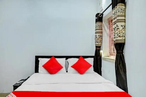 una camera da letto con un letto con cuscini rossi e bianchi di Hotel Laxmi Guest House Jadavpur - Excellent Service a Calcutta