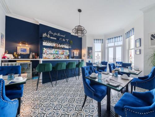 a restaurant with blue chairs and a bar at Lazy Waves Boutique B&B in Newquay