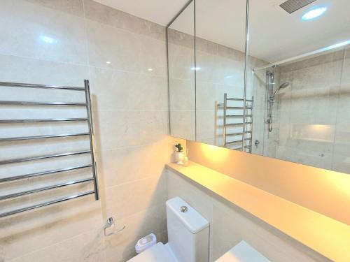 y baño con aseo, lavabo y ducha. en Holiday Style 2 BRStudy Apartment in Olympic Park, en Sídney