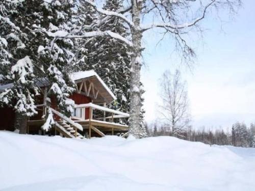 a log cabin in the snow next to a tree at Haus Rangen in Brograngen