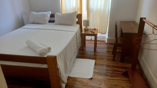 - une chambre avec deux lits, un piano et une table dans l'établissement Residencial Arca de Noé, à Santo António