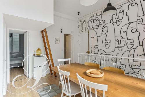 une salle à manger avec une table et des chaises dans l'établissement Milord, F3 à Père Lachaise, à Paris