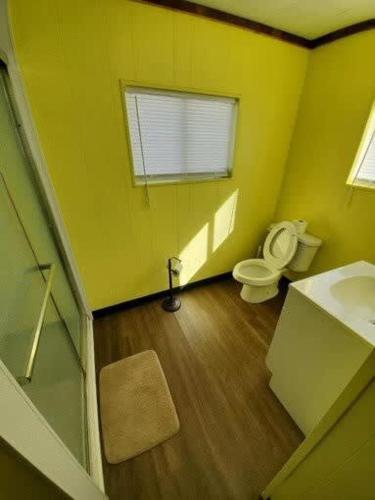 a yellow bathroom with a toilet and a sink at Spacious ATV Retreat House in Rock