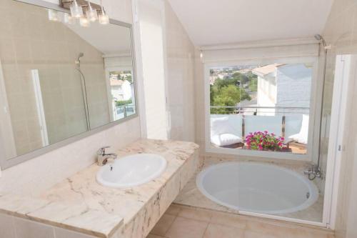 een badkamer met een wastafel en een grote spiegel bij Casa 11 Parc Sant Ramon descanso y armonía in S'Agaro