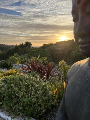 a statue of a person looking at the sunset at Quinta da Relva - Soulful House in Mafra
