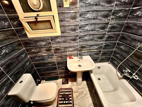 uma casa de banho com um WC, um lavatório e uma banheira em استوديو روف جديد وأنيق في المعادي no Cairo