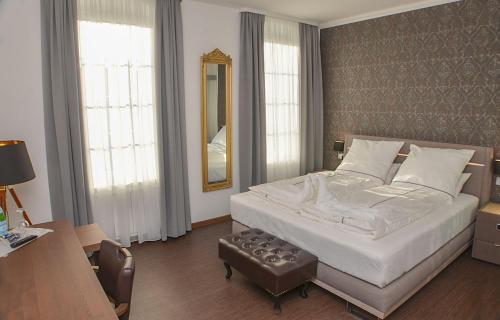 a bedroom with a bed and a desk and a mirror at Vittoria Hotel-Restaurant in Beverstedt