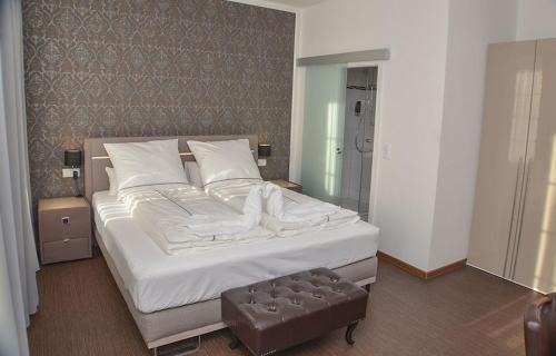 een slaapkamer met een groot bed met witte lakens bij Vittoria Hotel-Restaurant in Beverstedt