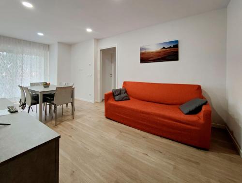 利尼亞諾薩比亞多羅的住宿－Casa Bivi 2，客厅配有橙色沙发和桌子