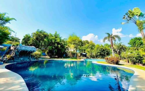 una piscina en un complejo con agua azul en Daily Bread Organic Farm & Resort, en Bustos