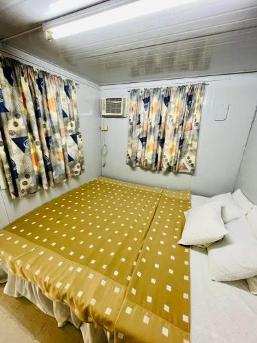 Habitación pequeña con cama amarilla. en Daily Bread Organic Farm & Resort, en Bustos