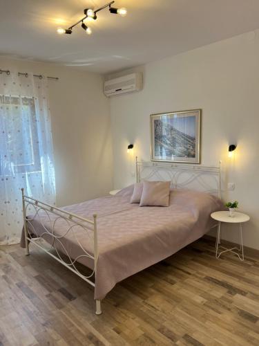 a bedroom with a bed and a table at Apartmani Vranković in Sveta Nedelja