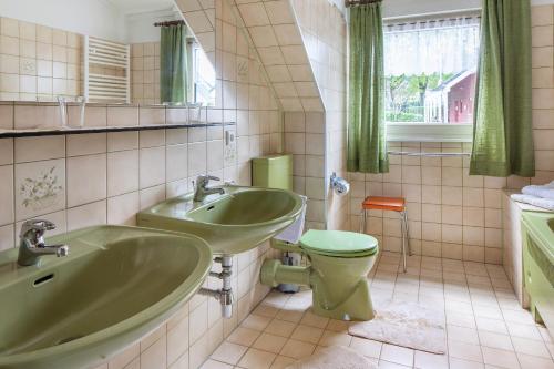 a bathroom with two sinks and a toilet at Zum Alt Engelwirt in Horben