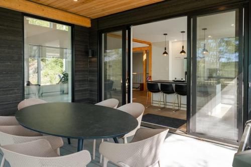 a dining room with a black table and chairs at Le Zen Belvédère in Sainte-Adèle