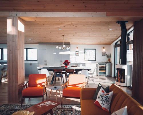 ein Esszimmer und ein Wohnzimmer mit Tisch und Stühlen in der Unterkunft Lakeview Mid Century Luxury Cottage in Sainte-Adèle