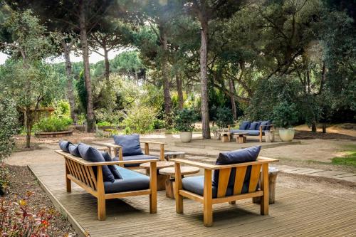 a group of chairs and tables on a wooden deck at Sublime Comporta Country Retreat & SPA in Comporta