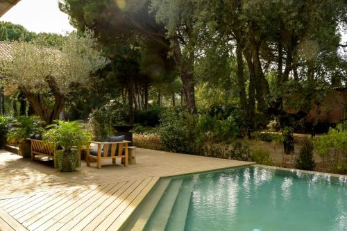 a swimming pool with two chairs and a wooden deck at Sublime Comporta Country Retreat & SPA in Comporta