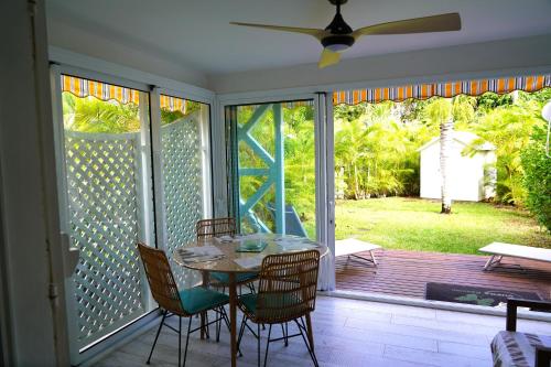 een eetkamer met een tafel en stoelen op een veranda bij Dodo Coconut lagon Ermitage in Saint-Gilles-les-Bains