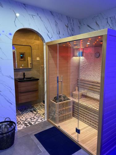 een badkamer met een douche, een wastafel en een wastafel bij La nuit de rêve Spa privatif Jaccuzi Sauna suite 1 in Crouy