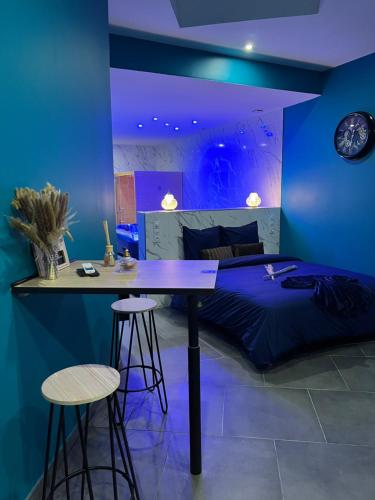 Crouy的住宿－La nuit de rêve Spa privatif Jaccuzi Sauna suite 1，一间卧室配有一张床、一张桌子和凳子