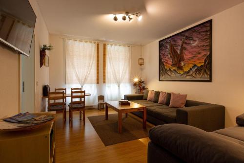 ein Wohnzimmer mit einem Sofa und einem Tisch in der Unterkunft Ferienwohnung am Auensee in Leipzig