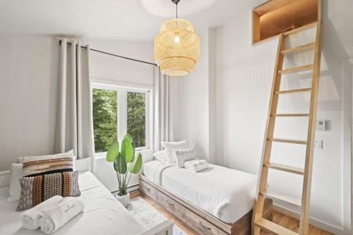 a bedroom with two beds and a ladder at Chalet La Colline in Labelle