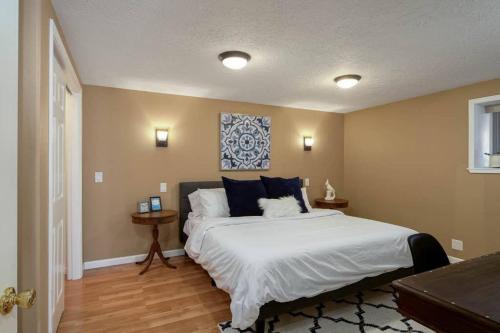 a bedroom with a large white bed with blue pillows at #StayinMyDistrict St Johns Forest Park Retreat in Portland