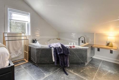 a large bathroom with a tub and a sink at Le mini chalet in Sainte Anne des Lacs