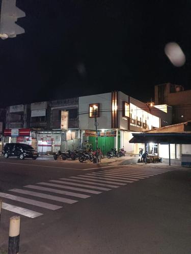 a building with motorcycles parked on the street at night at Losmen cempaka in Sibengkok