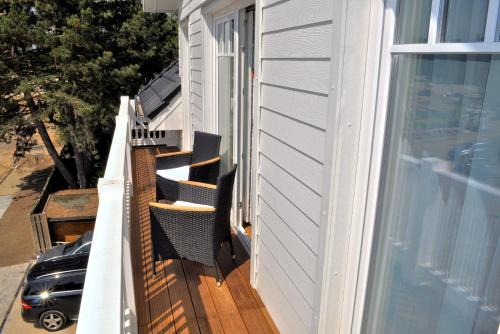 einen Balkon mit Stühlen und ein Fenster zum Haus in der Unterkunft Villa Somersby Ferienwohnung Nr 05 in Niendorf