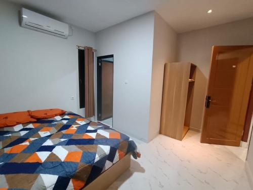 1 dormitorio con 1 cama y puerta abierta en Losmen cempaka en Sibengkok