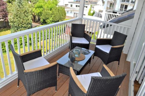 eine Terrasse mit Stühlen und einem Tisch auf dem Balkon in der Unterkunft Villa Somersby Ferienwohnung Nr 05 in Niendorf