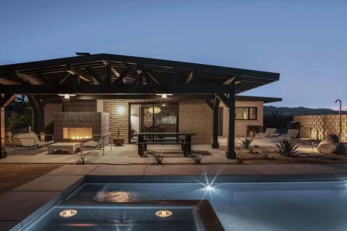 a patio with a picnic table and a fireplace at Escondite: Modern Desert Hideout w Pool + Spa in Landers