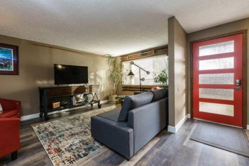 a living room with a couch and a flat screen tv at #StayInMyDistrict Eclectic Boise Townhouse near St Als in Boise