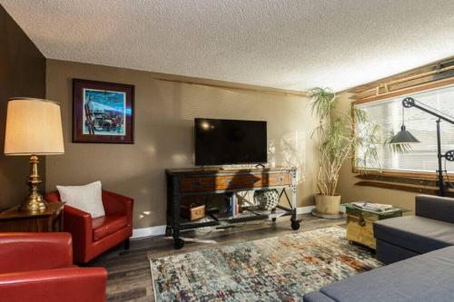 a living room with a flat screen tv and a red couch at #StayInMyDistrict Eclectic Boise Townhouse near St Als in Boise