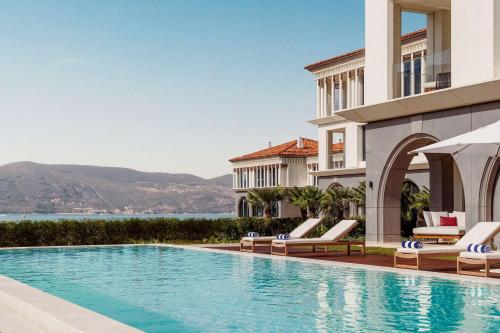 eine Villa mit einem Pool neben einem Gebäude in der Unterkunft One&Only Portonovi in Herceg-Novi