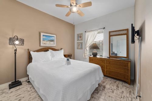 - une chambre avec un lit blanc et un ventilateur de plafond dans l'établissement Romar Lakes 302-B, à Orange Beach