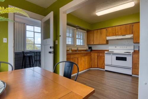 a kitchen with wooden cabinets and a table with a dining room at #StayinMyDistrict Historic Apartment Near Downtown in Coos Bay