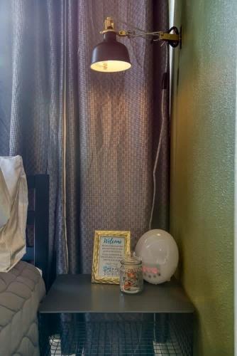 a table with a lamp and a sign on it at #StayinMyDistrict Historic Apartment Near Downtown in Coos Bay