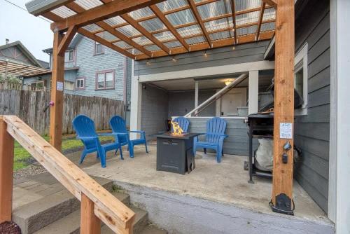 a patio with blue chairs and a table and a piano at #StayinMyDistrict Historic Apartment Near Downtown in Coos Bay