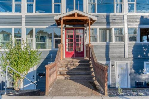 a house with a red door and stairs at #StayinMyDistrict Historic Apartment Near Downtown in Coos Bay