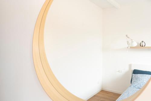 een spiegel in een witte kamer met een blauwe stoel bij LO3 • [Navigli] Chic Apartment • in Milaan