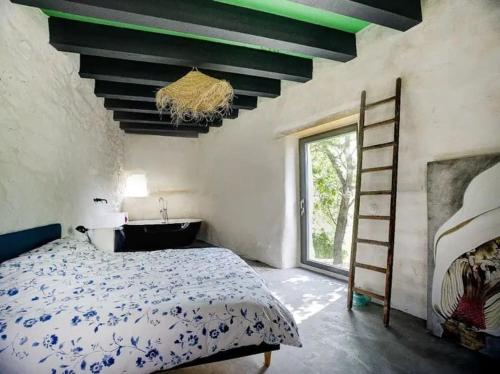 een slaapkamer met een bed, een bad en een raam bij Ardeche Nature 