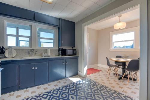 a kitchen with blue cabinets and a table with chairs at #StayinMyDistrict Heritage House Private Suite in Coos Bay