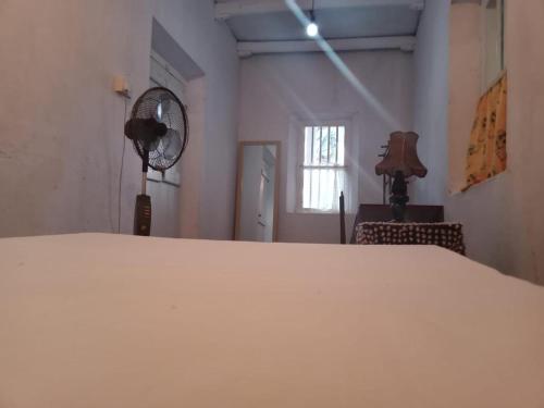una camera con letto bianco e ventilatore di Salis House a Galle