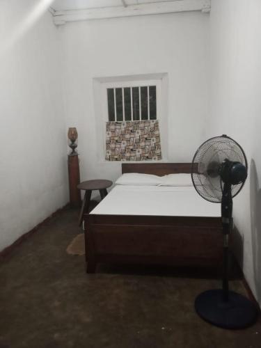 una camera con letto, ventilatore e finestra di Salis House a Galle