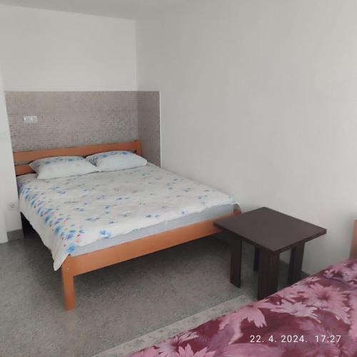 Un dormitorio con una cama y una mesa. en Apartman Numero Uno en Vogošća