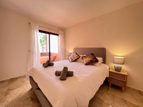 una camera da letto con un letto con due orsacchiotti sopra di Modern 2 Bedroom Beachside Apartment NR72 a Los Alcázares