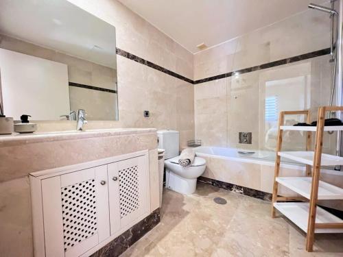 a bathroom with a sink and a toilet and a tub at Modern 2 Bedroom Beachside Apartment NR72 in Los Alcázares